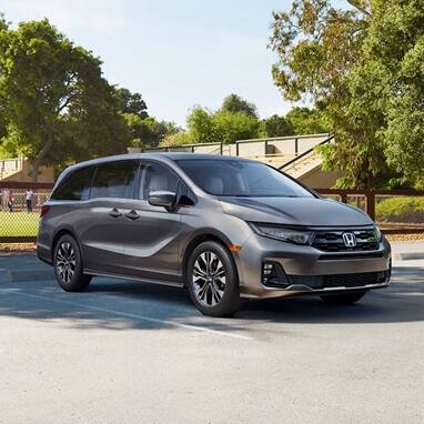 Front view of the 2027 Honda Odyssey minivan Elite in Modern Steel Metallic parked outdoors (Minivan).