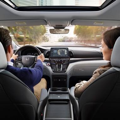 2027 Honda Odyssey Elite dashboard and front seats with driver and passenger looking forward (Minivan).